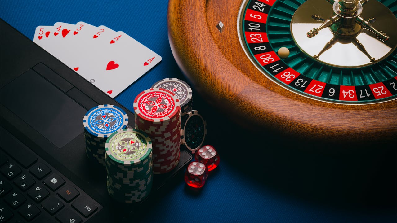 Close-up of a roulette table, poker chips, and playing cards depicting casino culture.